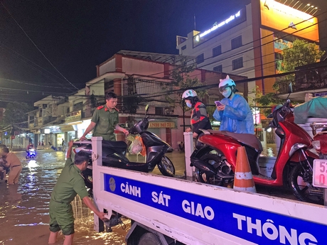 Công an TP Vĩnh Long kết hợp đoàn viên thanh niên các phường: 1, 4 và 9 điều tiết giao thông, sử dụng xe chuyên dụng chở người và phương tiện qua các đoạn ngập. Ảnh: NGUYỄN THỊNH