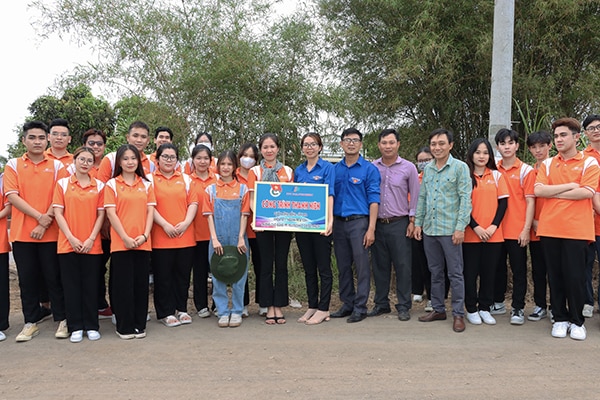 Tập thể Trường CĐ FPT Polytechnic (TP.Hồ Chí Minh) trao bảng tượng trưng công trình thanh niên “Thắp sáng đường quê” tại ấp Phước Thới.  Ảnh: MINH TÀI