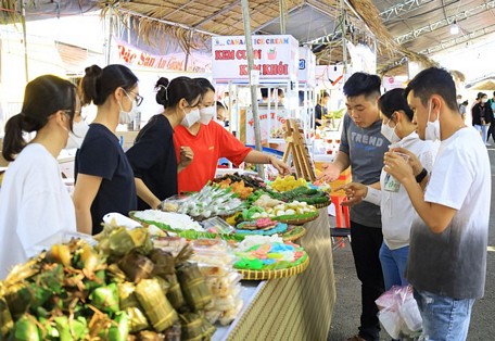 Đông đảo du khách tham quan lễ hội và thích thú thưởng thức các loại bánh dân gian với màu sắc bắt mắt