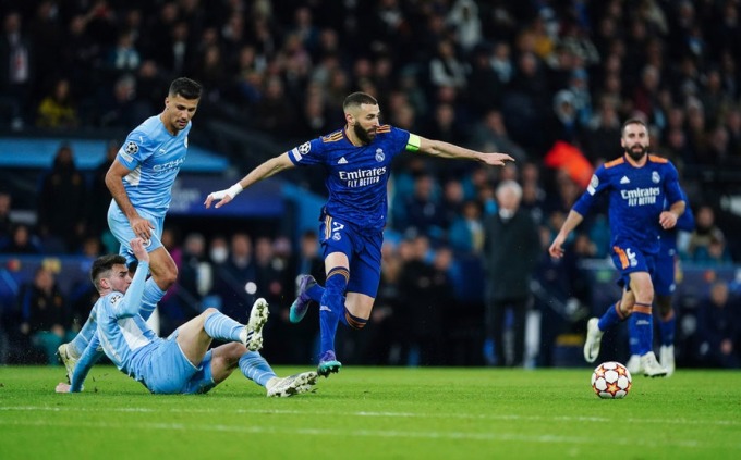 Benzema thoát khỏi một pha truy cản của hậu vệ Man City trong trận bán kết lượt đi Champions League mùa trước, khi Real thua 3-4 tại Etihad. Ảnh: DPA