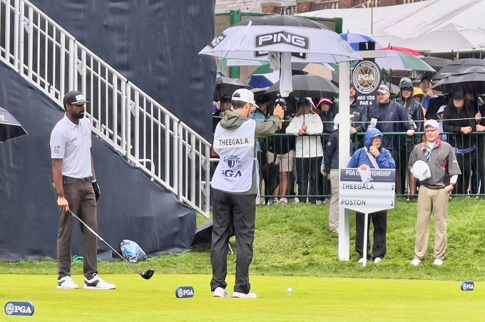 Caddie Carl Smith che ô để giữ bóng khỏi ướt khi Sahith Theegala chuẩn bị phát bóng cú đầu ở vòng ba PGA Championship ngày 20/5. Ảnh: Golfweek