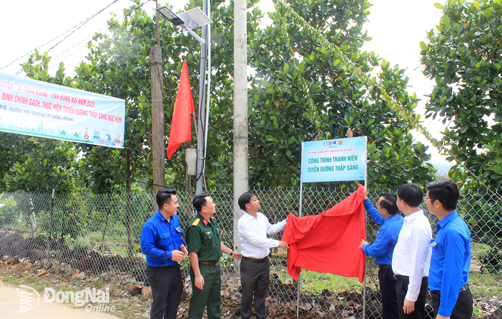 Các đại biểu thực hiên nghi thức khánh thành tuyến đường thắp sáng ngõ hẻm sau lễ ra quân