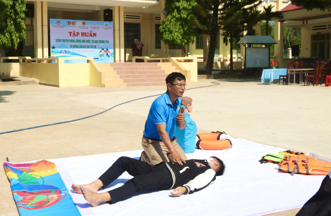 Thầy Mai Văn Chuyền (Chủ nhiệm câu lạc bộ Vì đàn em thân yêu) hướng dẫn học sinh sơ cứu cho người bị đuối nước.