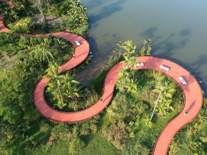 Khung cảnh con đường lót ván gỗ màu đỏ cam, uốn khúc dọc theo bờ hồ Jurong Lake từ trên cao. Ảnh: NPParks