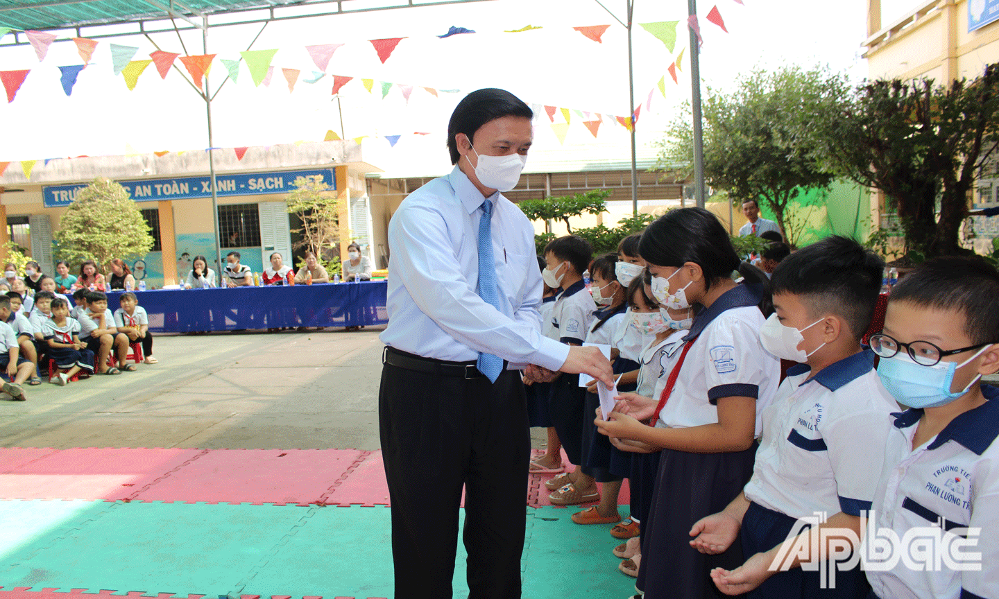 Đồng chí Nguyễn Văn Danh phát học bổng cho học sinh. 