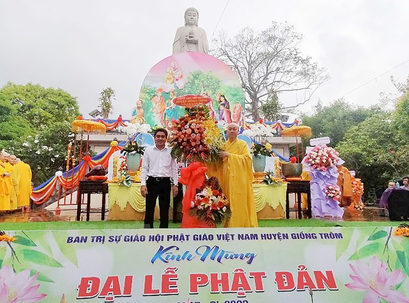 Chủ tịch Ủy ban MTTQ Việt Nam huyện Từ Xuân Tiếng tặng hoa chúc mừng Đại lễ Phật Đản. Ảnh: Diệu Hiền