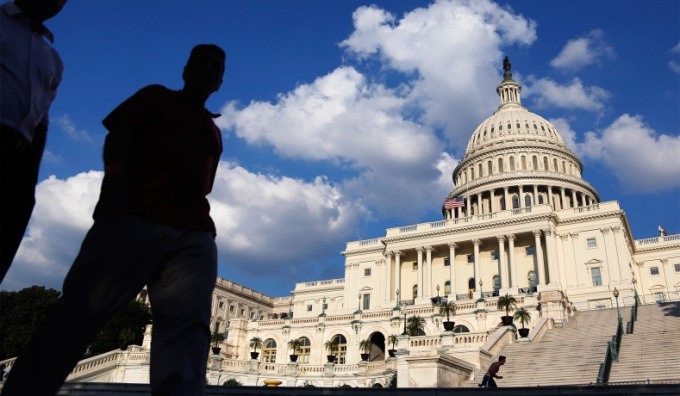 Khách du lịch đi qua tòa nhà quốc hội Mỹ ở Washington. Ảnh: Reuters