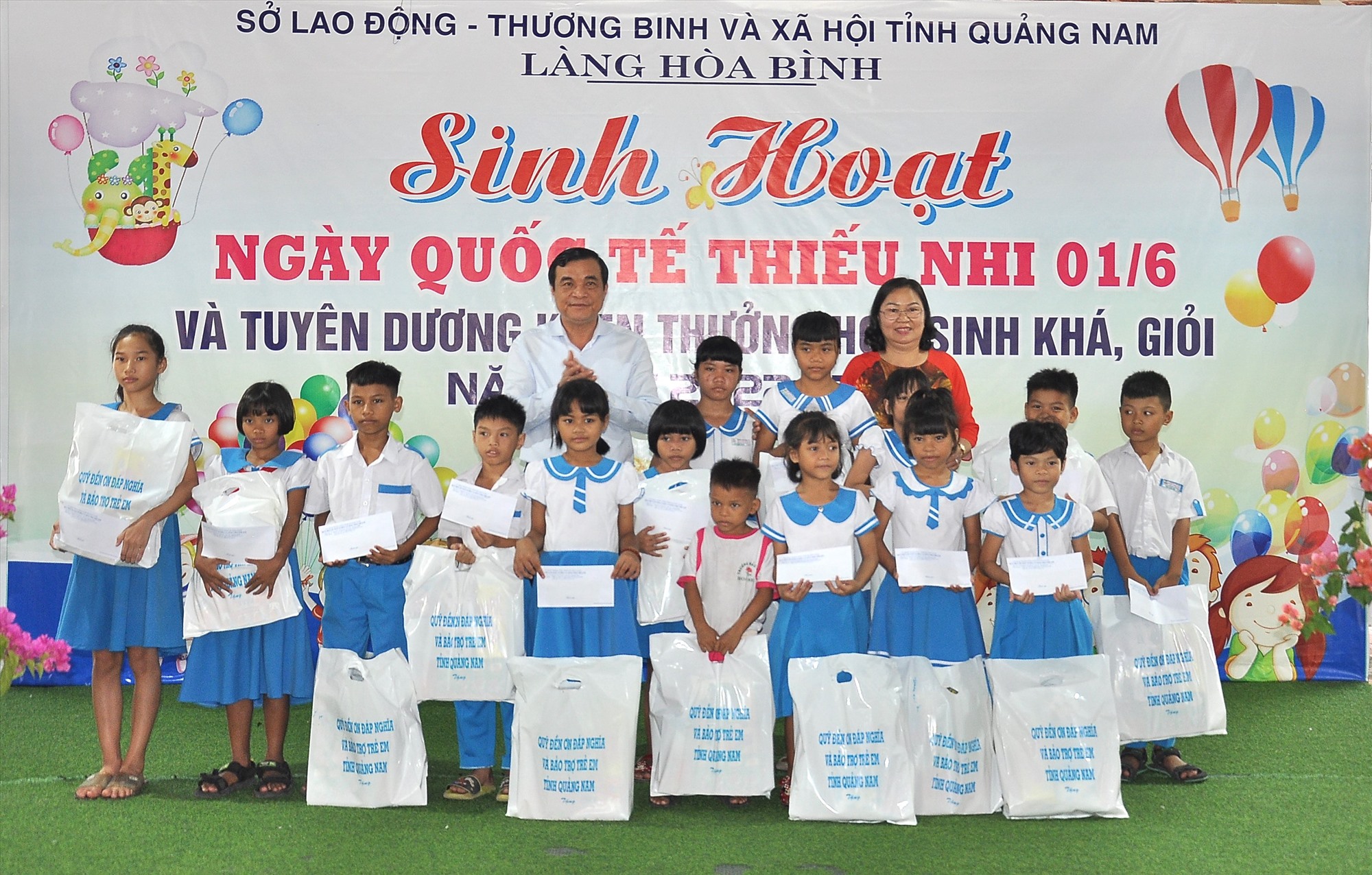 Provincial Party Secretary Phan Viet Cuong and Director of the Department of Labor, Invalids and Social Affairs Truong Thi Loc presented gifts to children at Hoa Binh Village. Photo: V.A