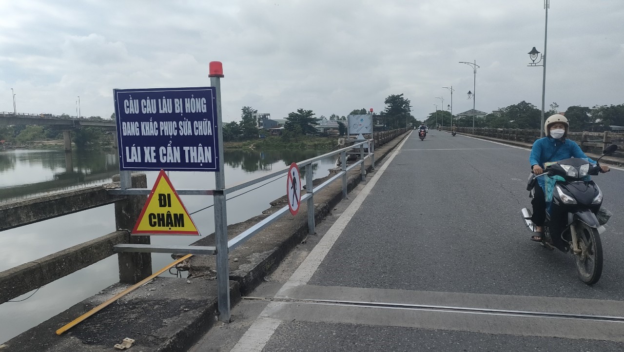 Lắp biển cảnh báo để phương tiện và người lưu thông qua cầu Câu Lâu (cũ) được đảm bảo an toàn. Ảnh: N.Q