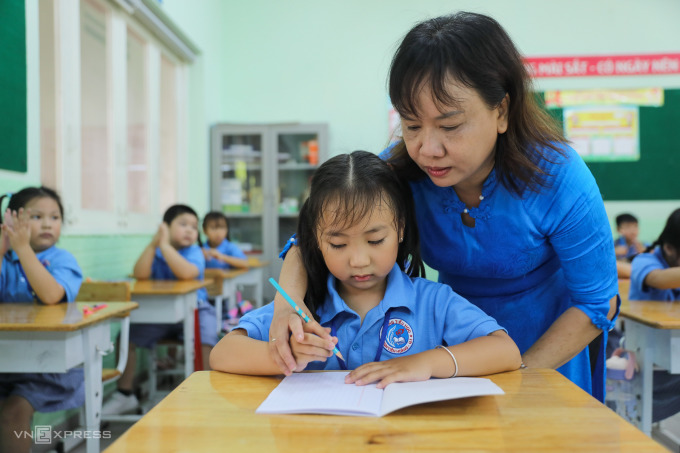 Giáo viên trường tiểu học Đinh Tiên Hoàng (quận 1, TP HCM) hướng dẫn học sinh lớp 1 trong ngày đầu đến trường, trong ngày đầu đến trường năm học 2022-2023. Ảnh: Quỳnh Trần