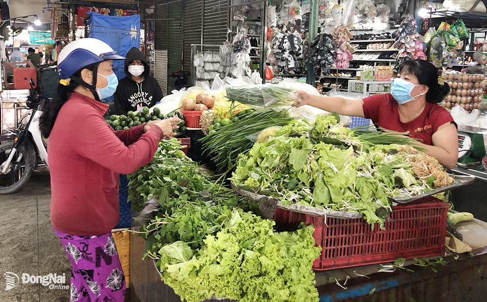 Người tiêu dùng chọn mua các loại rau xanh tại chợ Hóa An (TP.Biên Hòa). Ảnh: HẢI QUÂN