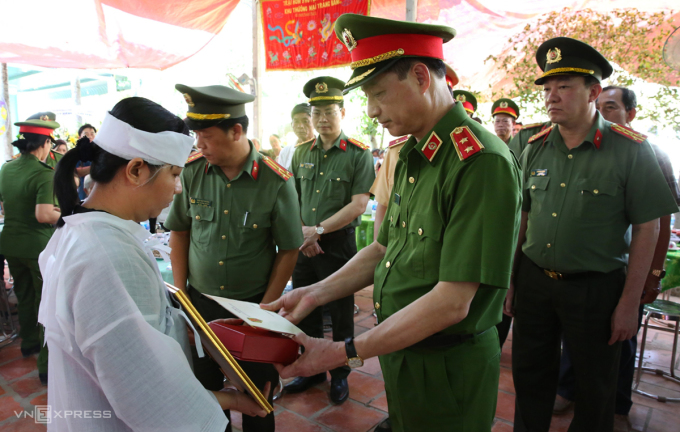 Trung tướng Nguyễn Duy Ngọc, Thứ trưởng Công an, trao quyết định thăng quân hàm cho gia đình trung tá Nguyễn Xuân Hào, hôm 23/4. Ảnh: Thúy Phượng