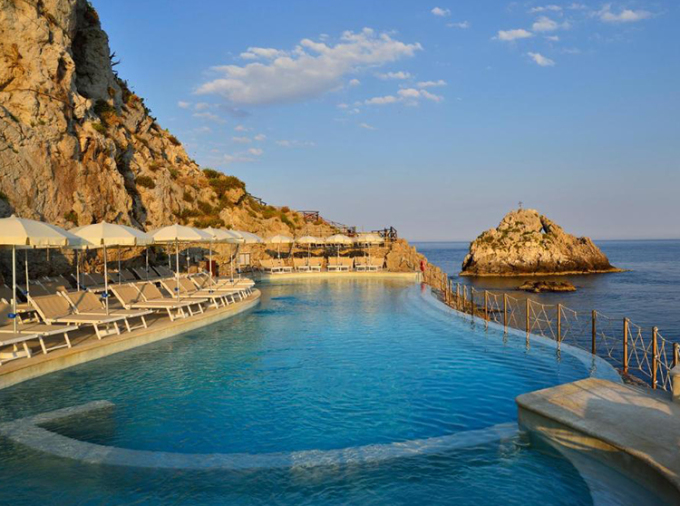 Thay vào đó, cô gợi ý ở tại khách sạn UnaHotels Capotaormina, giá 260 USD, rẻ hơn San Domenico Palace trong khi vẫn được hưởng những tiện ích tương tự như miễn phí bữa sáng, bể bơi vô cực (ảnh), có nhà hàng, quầy bar và bãi biển riêng. Ảnh: Booking