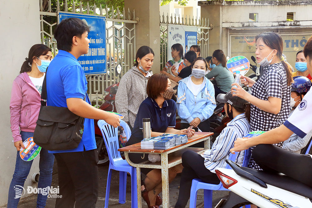 Phụ huynh tranh thủ ngồi “bàn chuyện” con thi cử trước cổng trường