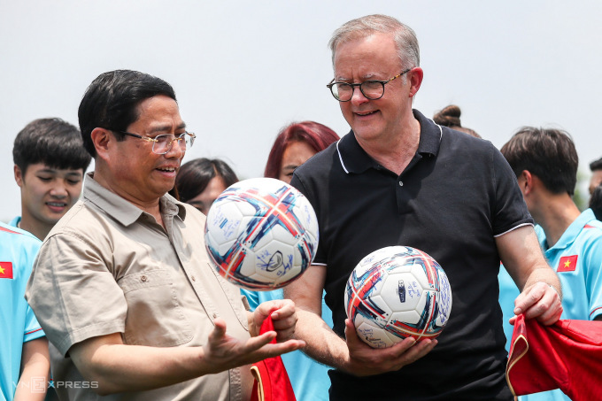 Thủ tướng Phạm Minh Chính và Thủ tướng Albanese cầm những quả bóng có chữ ký của hai đội tuyển trong sự kiện sáng 4/6. Ảnh: Giang Huy