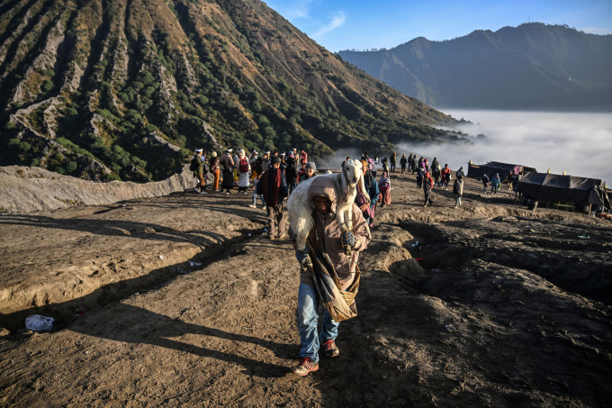 Thành viên bộ tộc Tengger vác dê tới lễ hiến tế ở núi lửa Bromo hôm 5/6. Ảnh: AFP