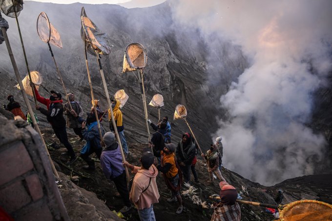 Dân làng mang dụng cụ bắt lễ vật hiến tế của bộ tộc Tengger trên đỉnh núi lửa Bromo hôm 5/6. Ảnh: AFP