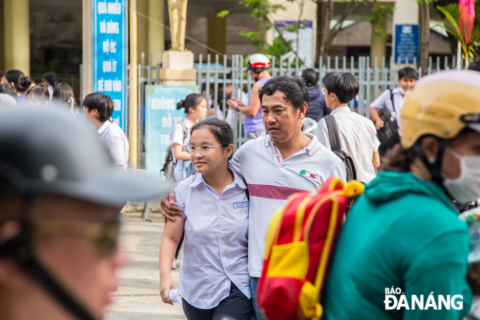 Người bố ôm con gái dắt qua đường với mong muốn con gái hãy bình tâm vượt qua kỳ thi lần này.