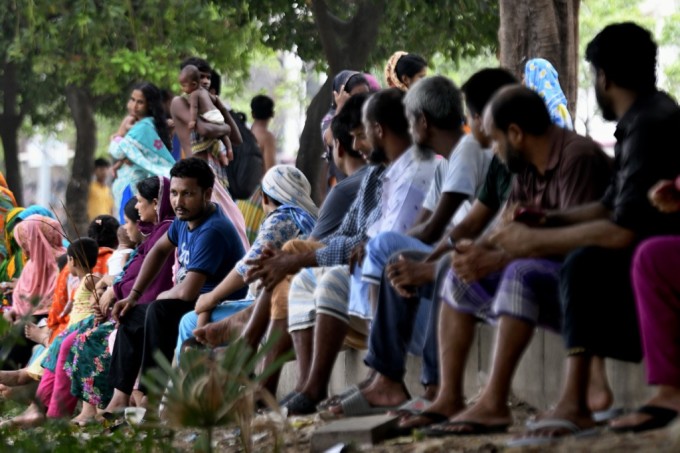 Người trong khu ổ chuột tụ tập gần hồ Hatirjheel tránh nóng ở Dhaka, ngày 7/6. Ảnh: AFP