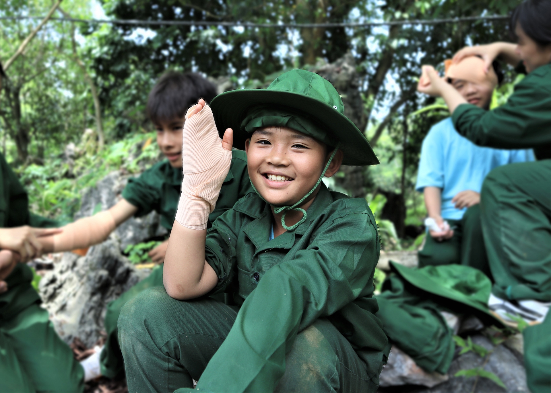 Một chiến sỹ nhí cười vui mừng khi hoàn thành bài tập kỹ năng băng bó vết thương nhanh hơn các bạn.