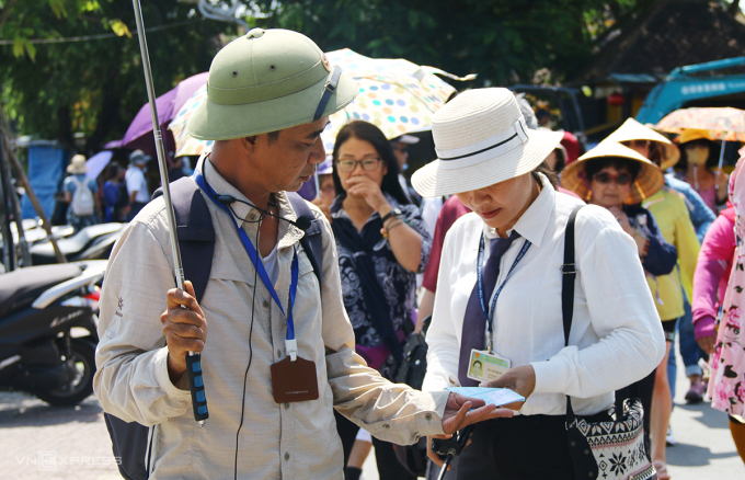 Nhân viên kiểm soát vé khách đoàn khi vào phố cổ tham quan. Ảnh: Đắc Thành