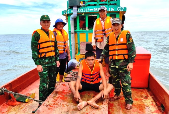 Lực lượng Biên phòng Sông Đốc cùng các ngư dân đưa nạn nhân (ngồi) vào đất liền. Ảnh: Lê Khoa