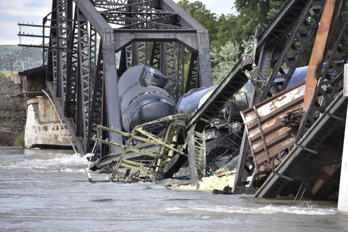 Several train cars are immersed in the Yellowstone River after a bridge collapse near Columbus, Mont., on Saturday, June 24, 2023. The bridge collapsed overnight, causing a train that was traveling over it to plunge into the water below.