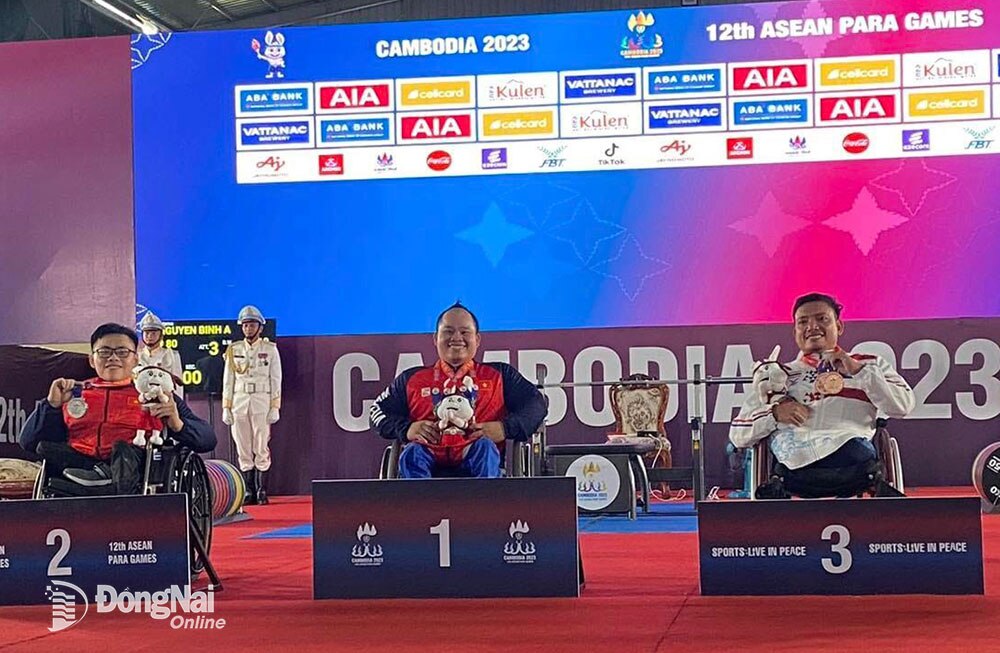 Huỳnh Ngọc Phụng (bìa trái) nhận HCB hạng cân 54kg nam môn cử tạ tại ASEAN PARA Games 12