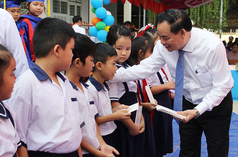 Chủ tịch UBND tỉnh Trần Ngọc Tam trao học bổng cho học sinh Trường Tiểu học An Ngãi Trung.