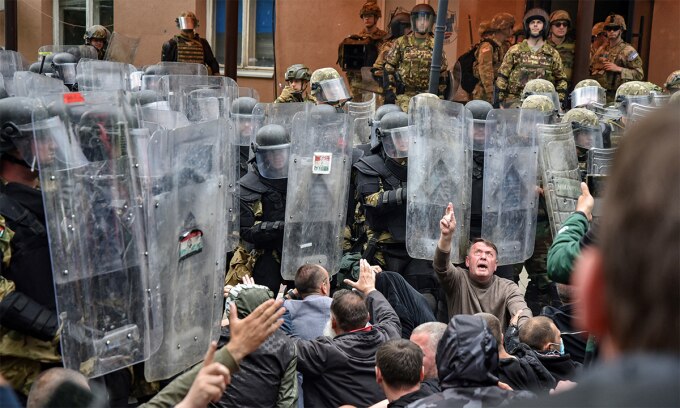 Người biểu tình gốc Serbia ngồi trước các binh sĩ NATO tại thị trấn Zvecan, Kosovo ngày 29/5. Ảnh: Reuters