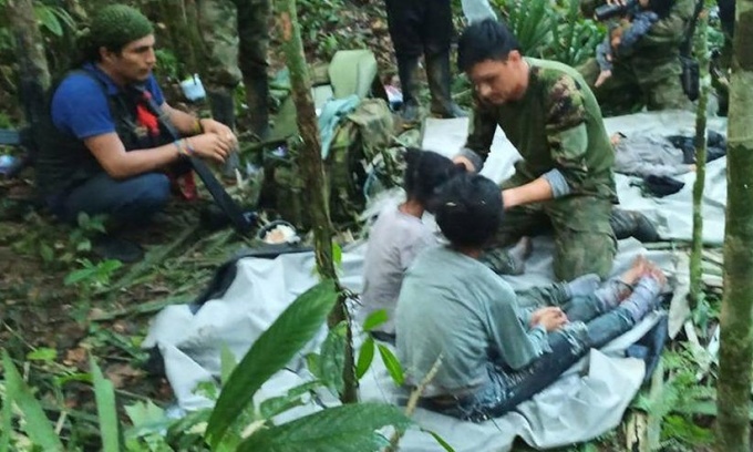 Binh sĩ Colombia chăm sóc các em nhỏ sau khi tìm thấy 4 đứa trẻ trong rừng ngày 9/6. Ảnh: Reuters