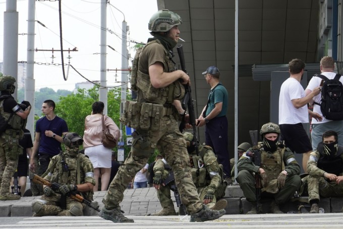 Lính Wagner ngồi trên vỉa hè khi tuần tra trung tâm Rostov-on-Don, ngày 24/6. Ảnh: AFP