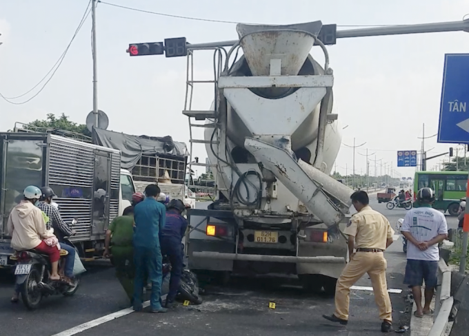 Cảnh sát khám nghiệm hiện trường, kéo xe máy kẹt dưới gầm ôtô bồn ra ngoài. Ảnh: Hồ Đinh