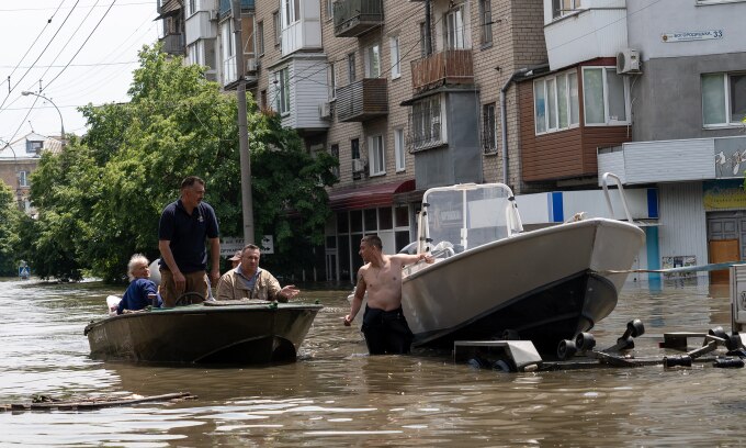 Người dân di chuyển bằng thuyền trên đường phố ngập lụt ở Kherson ngày 7/6. Ảnh: AFP