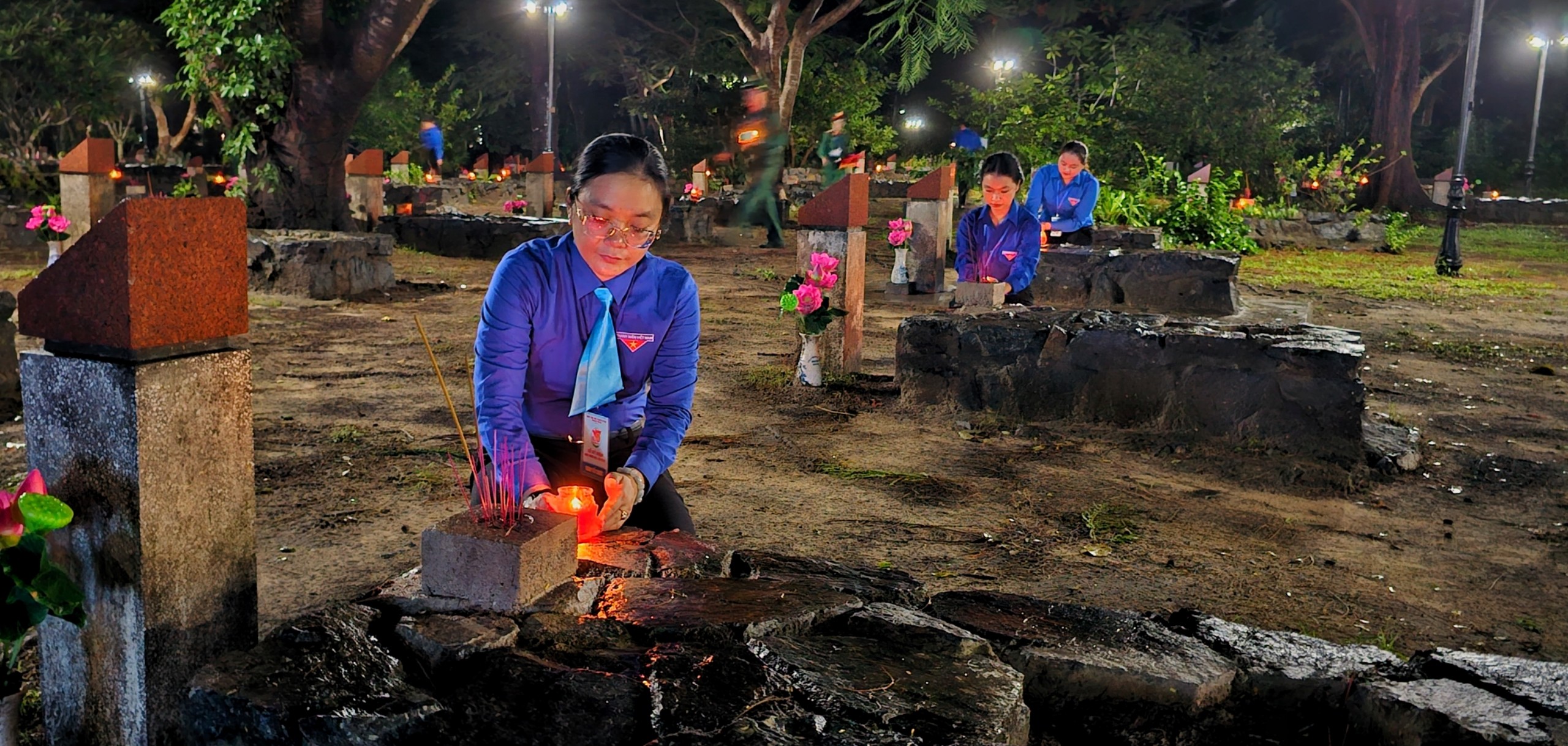 Các đoàn viên thanh niên thắp sáng mộ phần các anh hùng liệt sĩ bằng những ngọn nến lung linh.