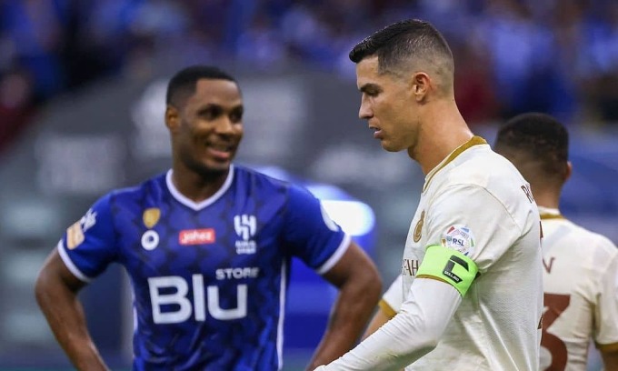 Ronaldo bước ngang qua Ighalo trong trận Al Nassr - Al Hilal ở Saudi Pro League mùa trước. Ảnh: AFP