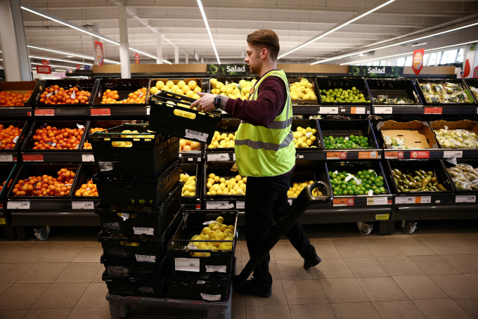 Một nhân viên sắp xếp sản phẩm bên trong siêu thị Sainsbury ở Richmond, London, ngày 27/6/2022. Ảnh: Reuters