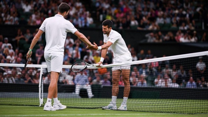 Djokovic (phải) bắt tay Hurkacz sau trận đấu vòng bốn Wimbledon trên sân Trung tâm hôm 10/7. Ảnh: Reuters