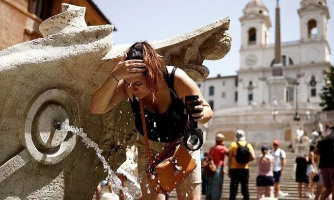 Nữ du khách làm mát cơ thể tại đài phun nước gần Bậc thang Tây Ban Nha ở Rome, Italy, ngày 17/7. Ảnh: Reuters/Guglielmo Mangiapane.