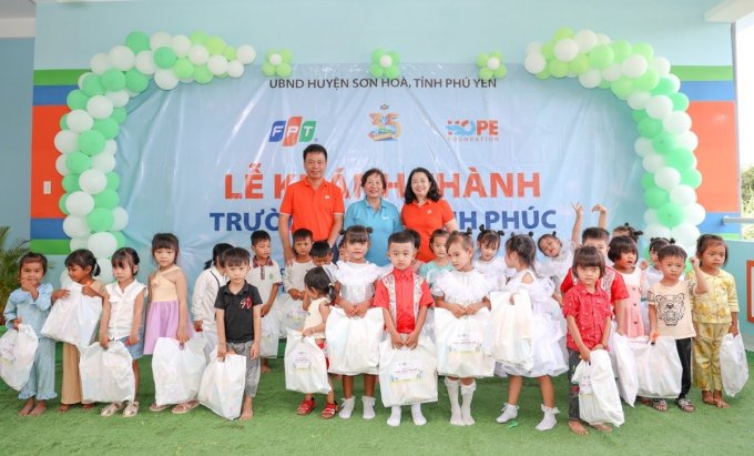 Đại diện Quỹ Hy Vong (áo xanh) cùng tập đoàn FPT trao quà cho học sinh tại điểm trường mầm non. Ảnh: Bùi Toàn