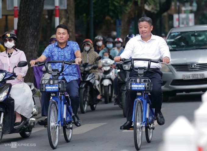 Phó Chủ tịch UBND TP Hà Nội Nguyễn Mạnh Quyền (áo trắng) chạy thử xe đạp điện trợ lực, sáng 24/8. Ảnh: Ngọc Thành