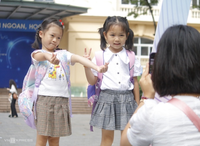 Khánh chi (trái) hào hứng chụp ảnh trong ngày đầu đến trường, sáng 1/8. Ảnh: Thanh Hằng