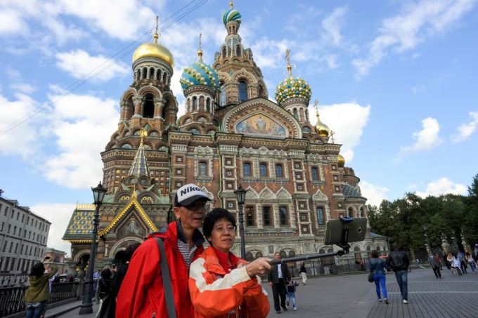 Du khách Trung Quốc chụp ảnh với gậy selfie tại St Petersburg. Ảnh: AP