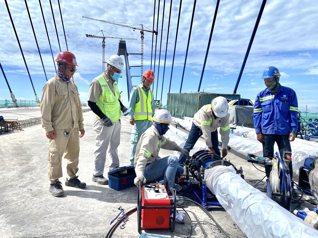 Công nhân đang thi công mối nối ống bảo vệ cáp dây văng - Ảnh: M.T.