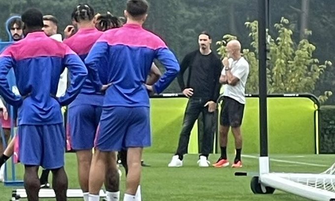 Ibrahimovic (bận đồ đen) trao đổi với HLV Pioli trong khi xem các cầu thủ Milan khởi động trước buổi tập tại Milanello sáng 18/9, giờ Rome. Ảnh: Instant Foot