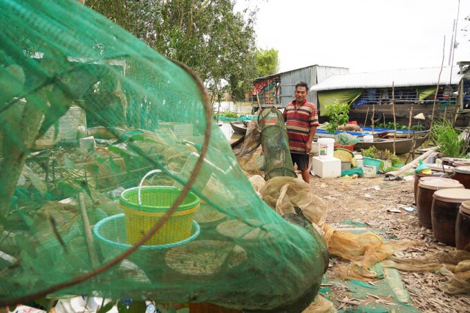 Gia đình bà Phụng đang vá lại các túi dớn đánh bắt cá mùa lũ. Ảnh: Hoàng Nam