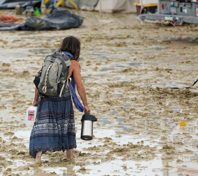 Người tham gia Burning Man bước trên bùn lầy ở sa mạc hôm 2/9. Ảnh: Reuters