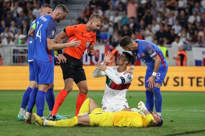 Ronaldo nhận thẻ vàng sau pha va chạm với thủ môn đội chủ nhà Slovakia, tối 8/9. Ảnh: LUSA