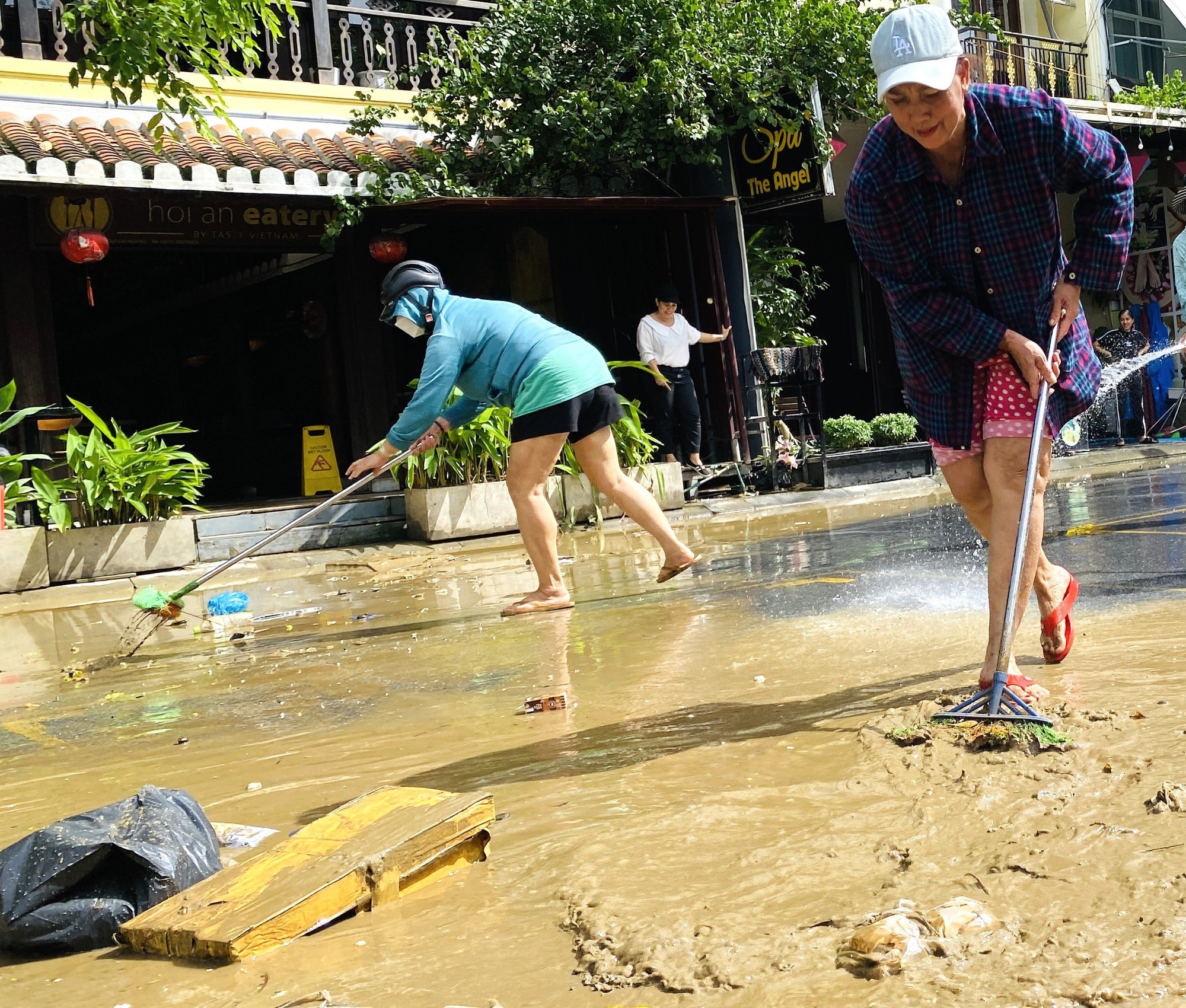 Tranh thủ lũ rút, người dân Hội An tất bật dọn bùn non để đón du khách - Ảnh 4.