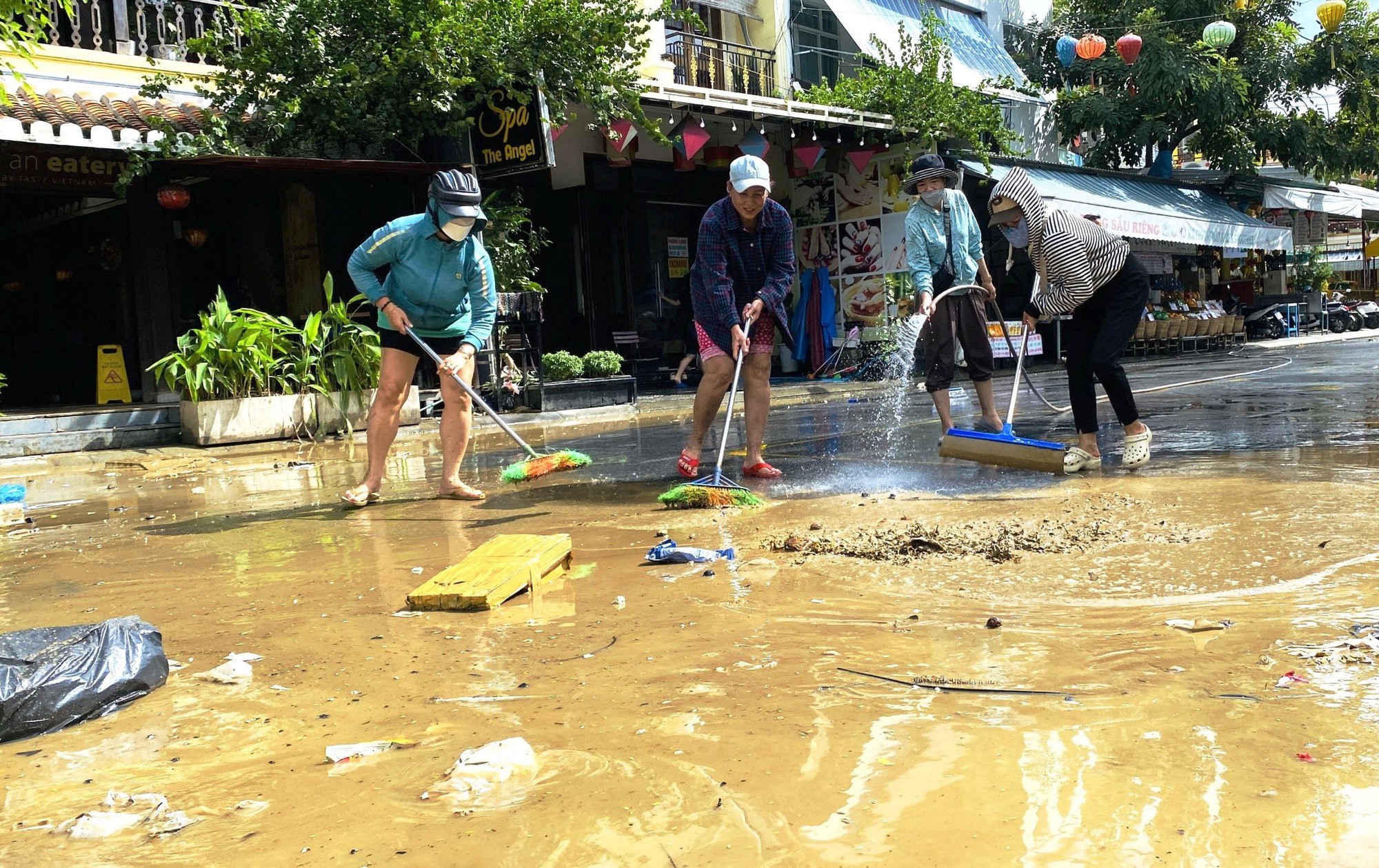 Tranh thủ lũ rút, người dân Hội An tất bật dọn bùn non để đón du khách - Ảnh 8.